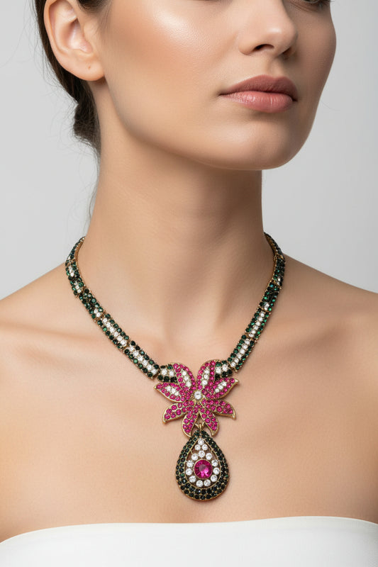 Necklace with a pink floral pendant and black and white gemstones on a white background