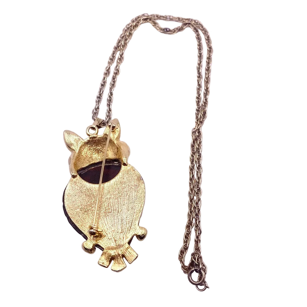 Gold owl-shaped pendant on a chain against a white background