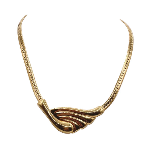 Gold necklace with a wing-shaped pendant on a white mannequin.
