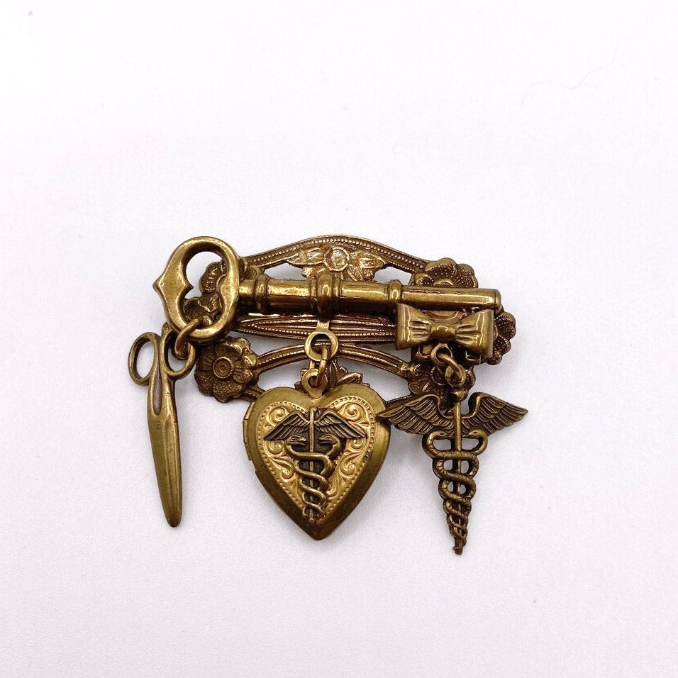Vntg Pin Filigree Charms Of Health Caduceus Symbol Scissors and Heart Locket